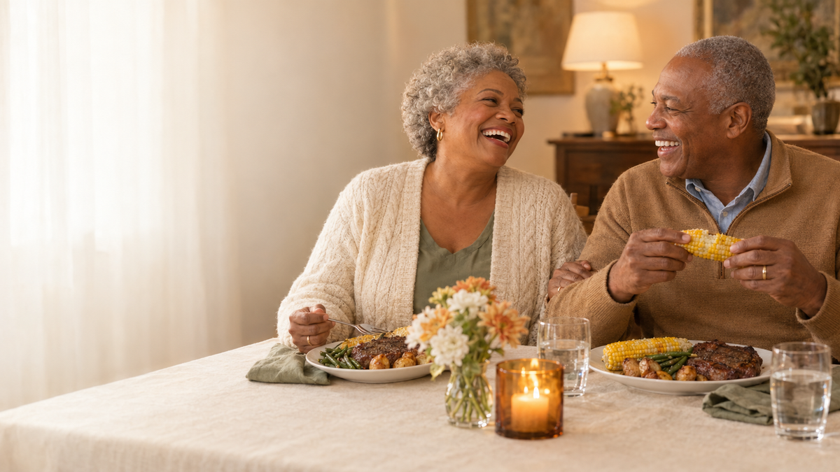 Couple in their 70s laughing over dinner
